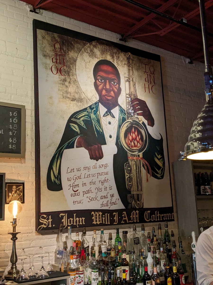 &lt;# Painting of John Coltraine, hanging above a bar #&gt;