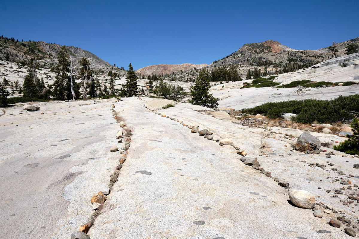 &lt;# A path across a granite slab, lined by small rocks on both sides #&gt;