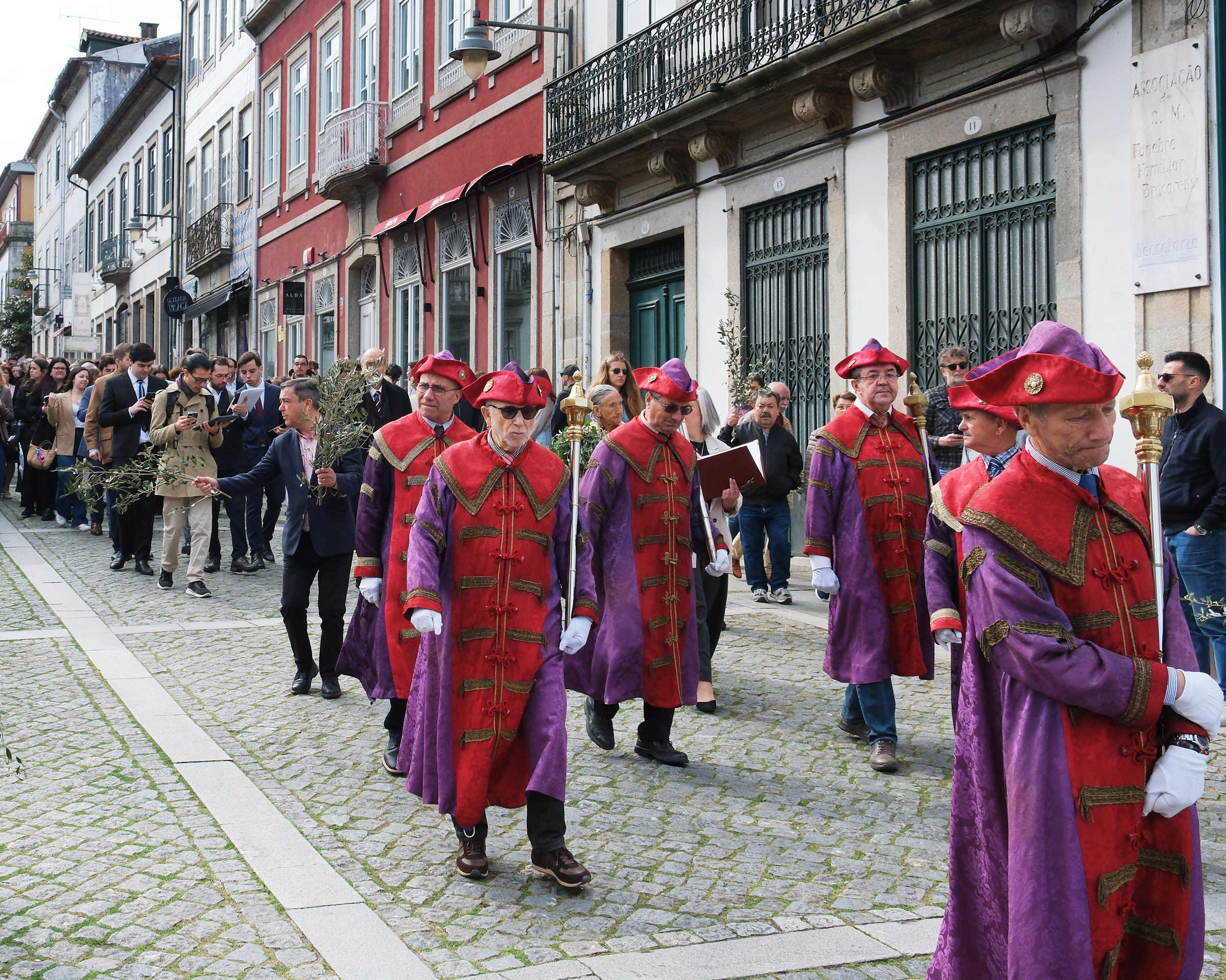 <# Deacons march in rich purple and red robes #>